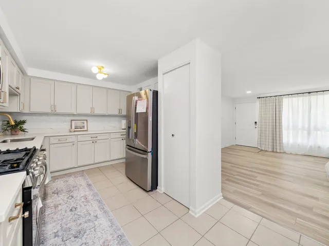 a kitchen with white cabinets and stainless steel appliances