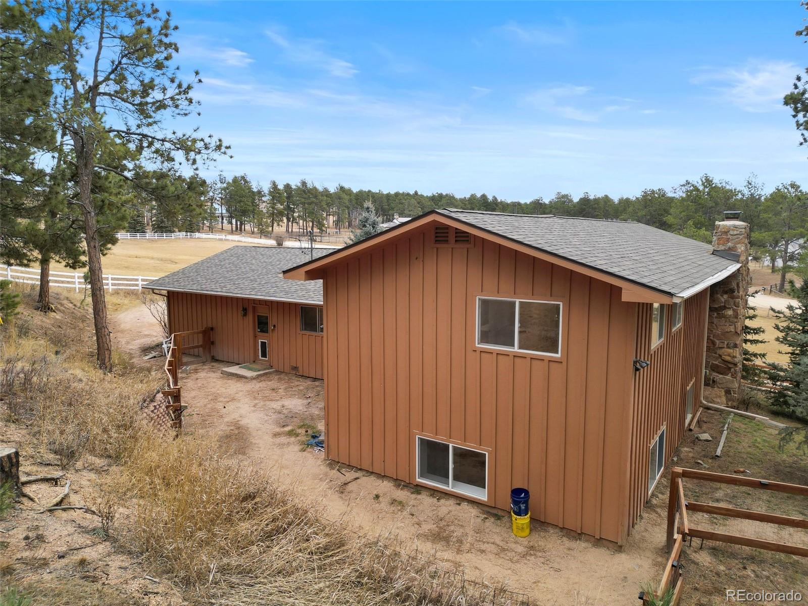 7020 Wildridge Road Colorado Springs, CO 80908 - Photo 12 of 45 a backyard of a house with large trees and wooden fence