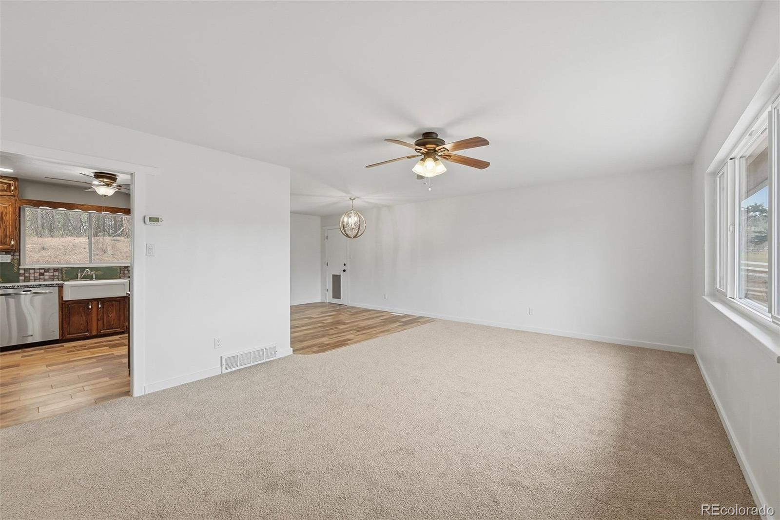 7020 Wildridge Road Colorado Springs, CO 80908 - Photo 17 of 45 an empty room with windows and chandelier fan