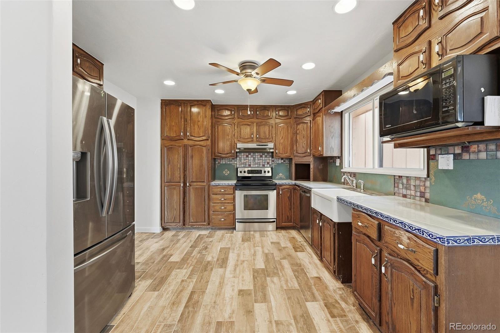 7020 Wildridge Road Colorado Springs, CO 80908 - Photo 21 of 45 a kitchen with granite countertop a refrigerator oven a sink dishwasher and a refrigerator with wooden floor