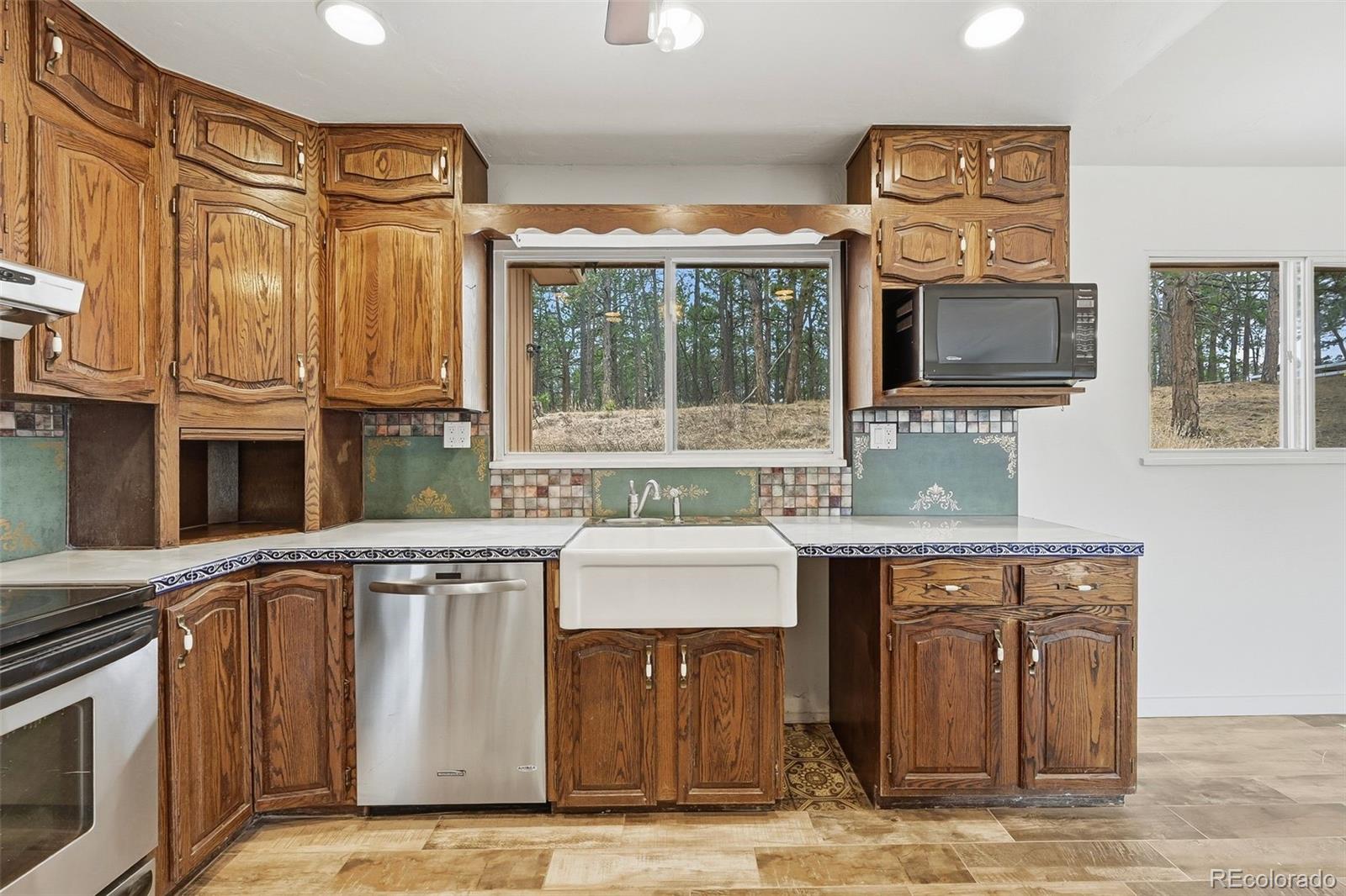 7020 Wildridge Road Colorado Springs, CO 80908 - Photo 22 of 45 a kitchen with stainless steel appliances granite countertop a stove and a sink
