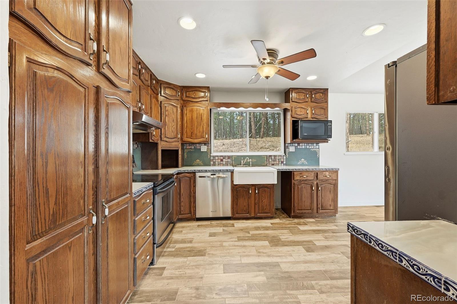 7020 Wildridge Road Colorado Springs, CO 80908 - Photo 24 of 45 a kitchen with stainless steel appliances kitchen island granite countertop a refrigerator and a stove top oven