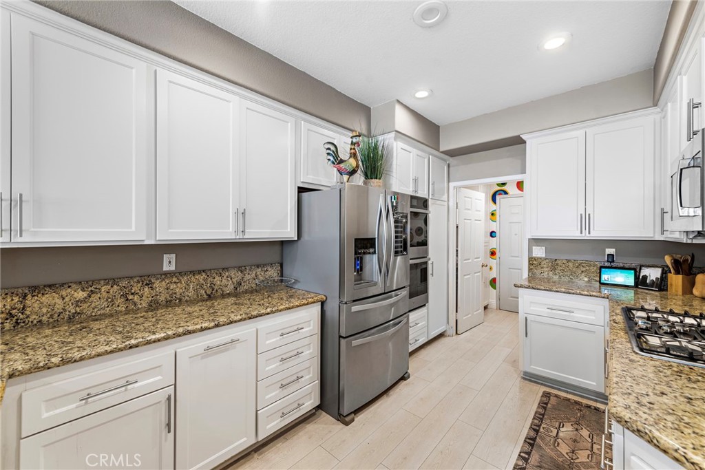 26481 La Scala Laguna Hills, CA 92653 - Photo 18 of 33 a kitchen with granite countertop a refrigerator sink and cabinets