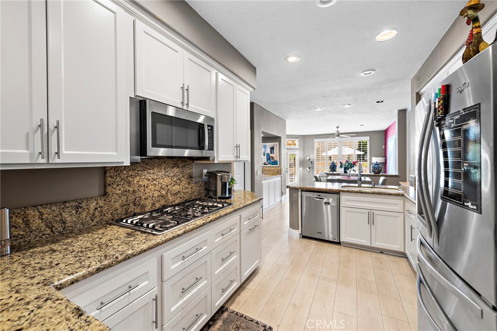 26481 La Scala Laguna Hills, CA 92653 - Photo 19 of 33 a kitchen with granite countertop a refrigerator stove and sink