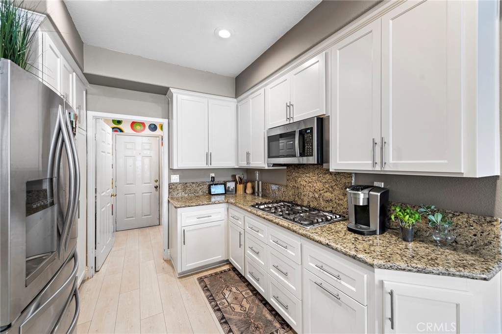 26481 La Scala Laguna Hills, CA 92653 - Photo 20 of 33 a kitchen with stainless steel appliances granite countertop a refrigerator sink and stove
