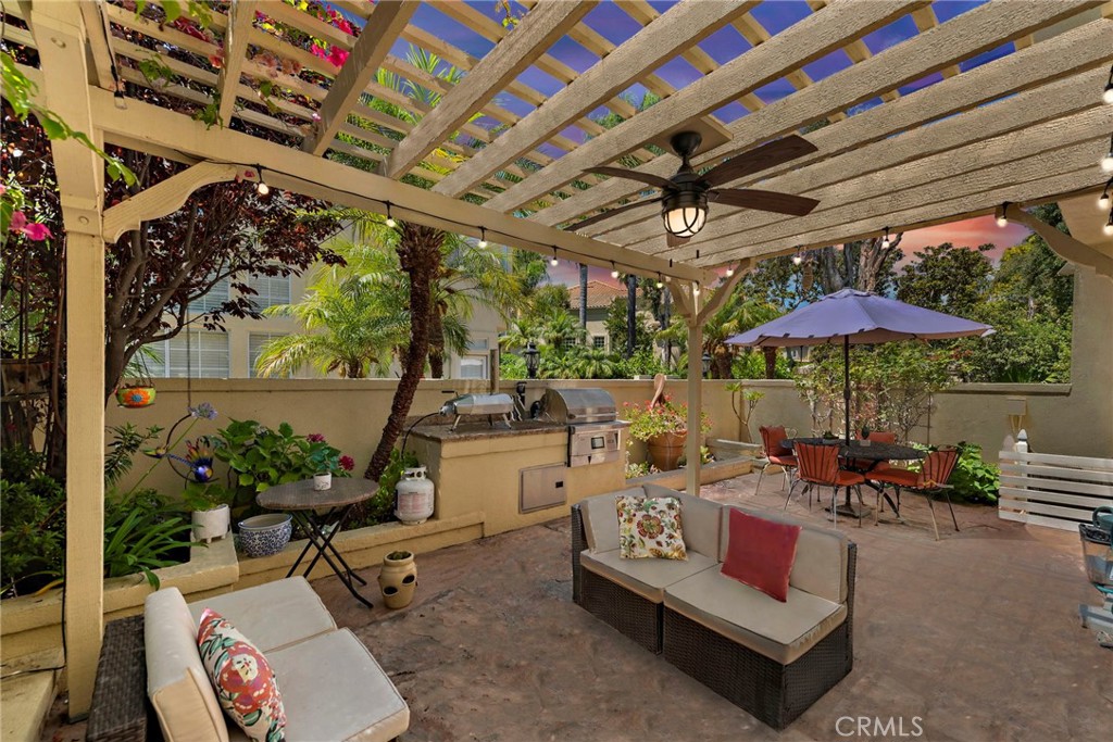 26481 La Scala Laguna Hills, CA 92653 - Photo 33 of 33 a roof deck with table and chairs under an umbrella with a barbeque