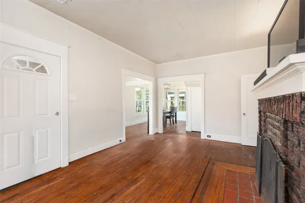 a view of a livingroom with wooden floor and a fireplace