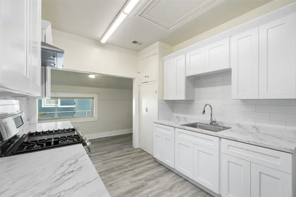 a kitchen with sink and stove top oven