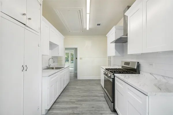 a kitchen with stainless steel appliances a sink stove top oven and cabinets