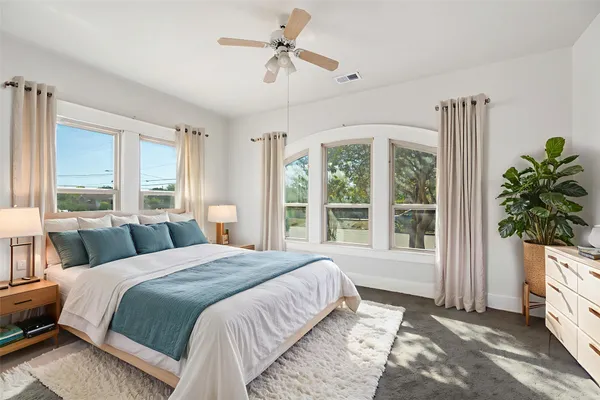 a bedroom with a large bed and a potted plant
