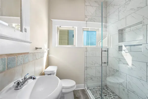 a bathroom with a sink a toilet and shower