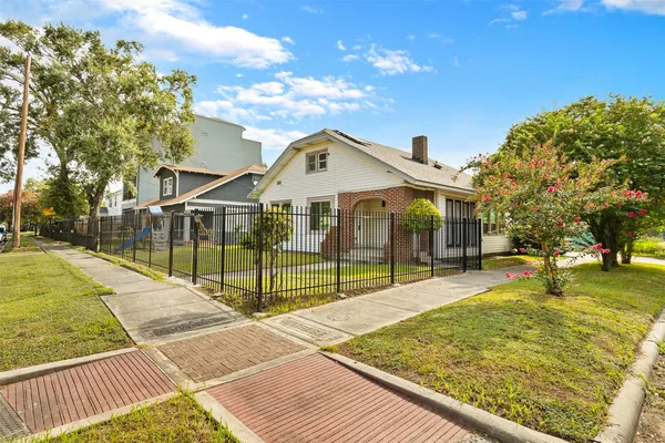 a view of a white house with a yard and plants