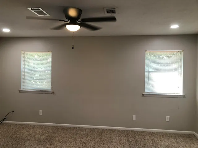 an empty room with windows and closet