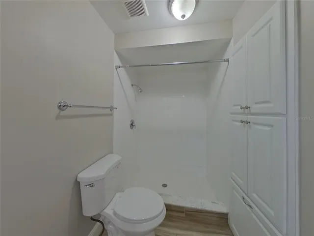 a white toilet sitting next to a shower