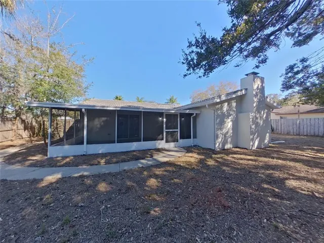 a view of a yard in front of a house with large tree