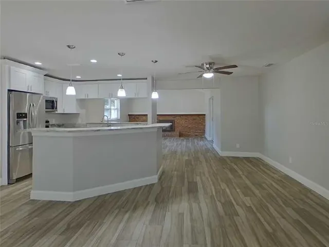 a view of kitchen with cabinets microwave and stove