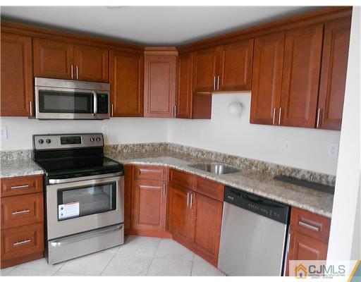 675 Bound Brook Road, Unit 10 Dunellen, NJ 08812 - Photo 3 of 7 a kitchen with stainless steel appliances granite countertop a stove microwave and sink