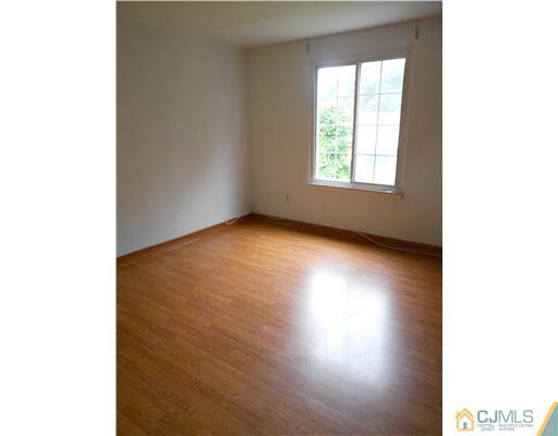 675 Bound Brook Road, Unit 10 Dunellen, NJ 08812 - Photo 7 of 7 a view of an empty room with wooden floor and a window