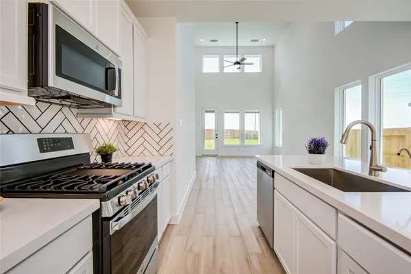 a kitchen with stainless steel appliances a sink stove and microwave