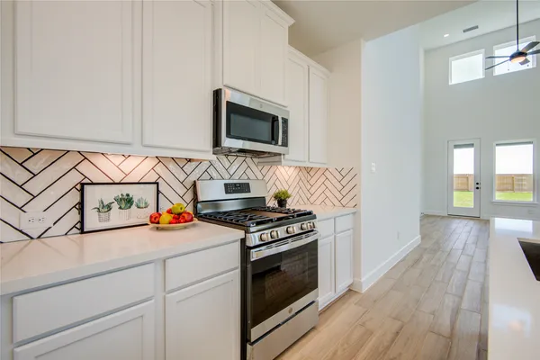 a kitchen with stainless steel appliances a stove microwave and cabinets