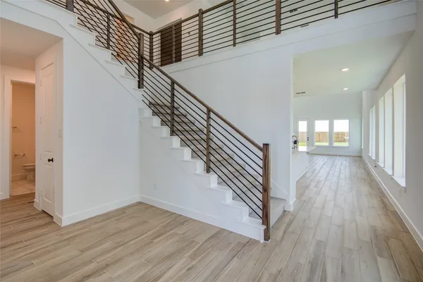 a view of a hallway with wooden floor and staircase