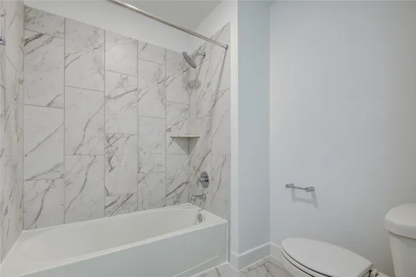 a bath room with a toilet and a bath tub