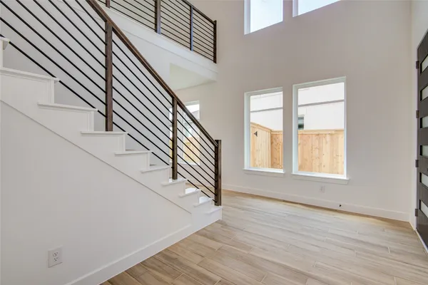 an entryway in a hall with wooden floor and a window