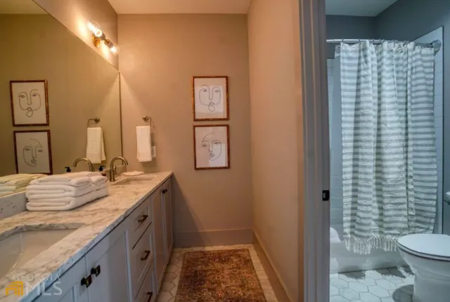 a bathroom with a granite countertop sink toilet and shower