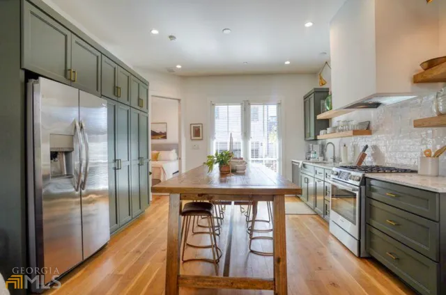 a kitchen with stainless steel appliances granite countertop a refrigerator a stove and a wooden floors