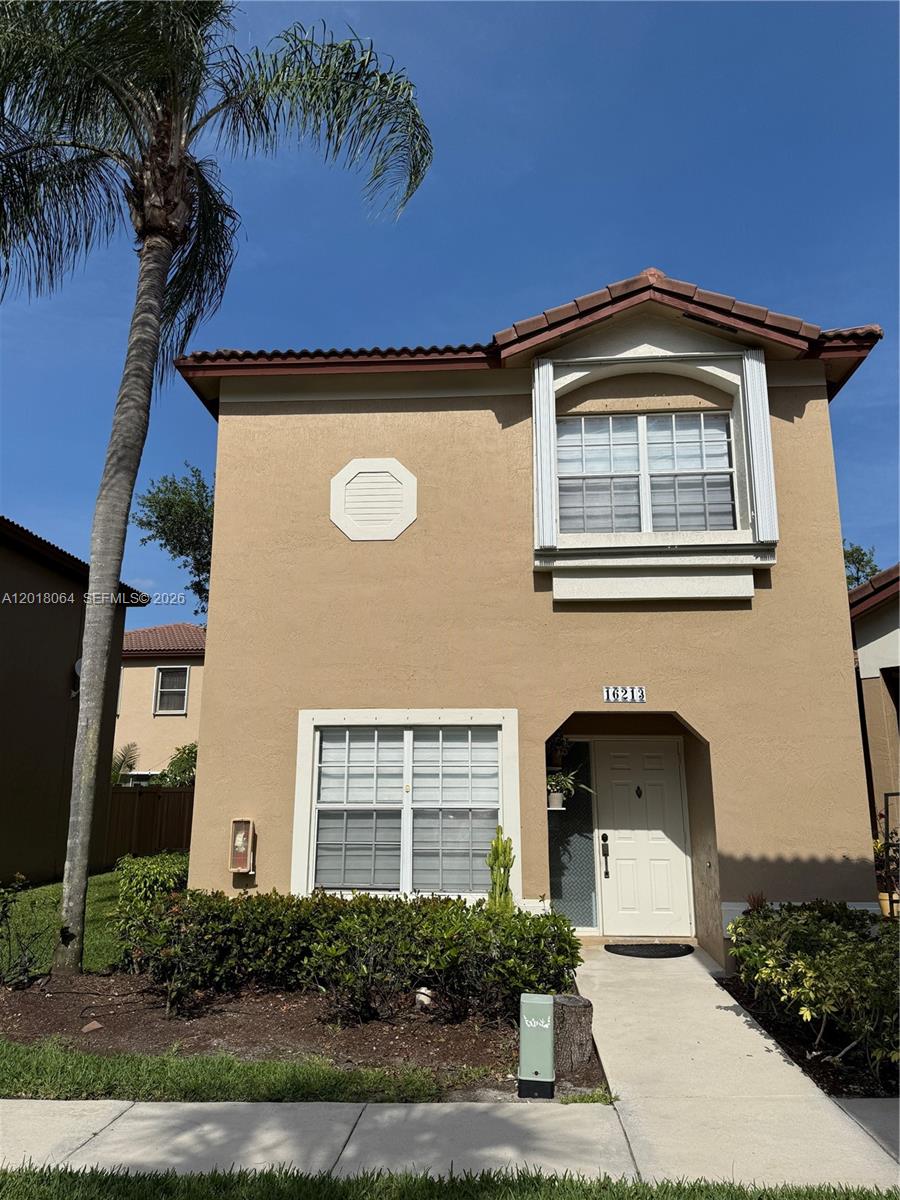 16213 Emerald Cove Road Weston, FL 33331 - Photo 19 of 27 a front view of a house with a yard