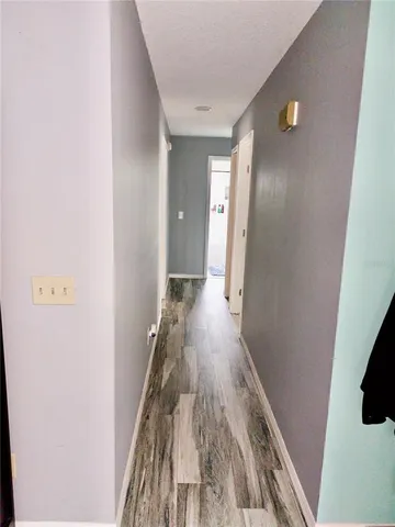 a view of a hallway with wooden floor