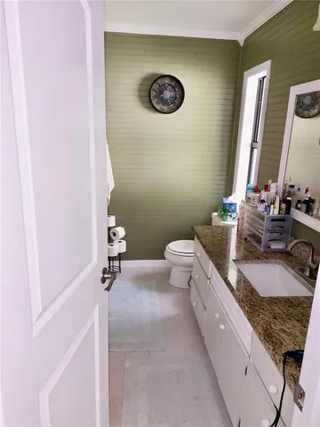 a bathroom with a granite countertop toilet and a sink