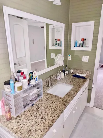 a bathroom with a granite countertop sink and a mirror