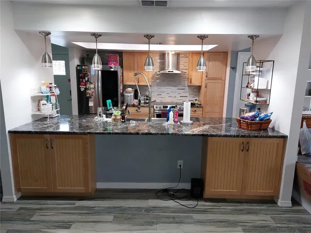 a kitchen with stainless steel appliances granite countertop a refrigerator and stove