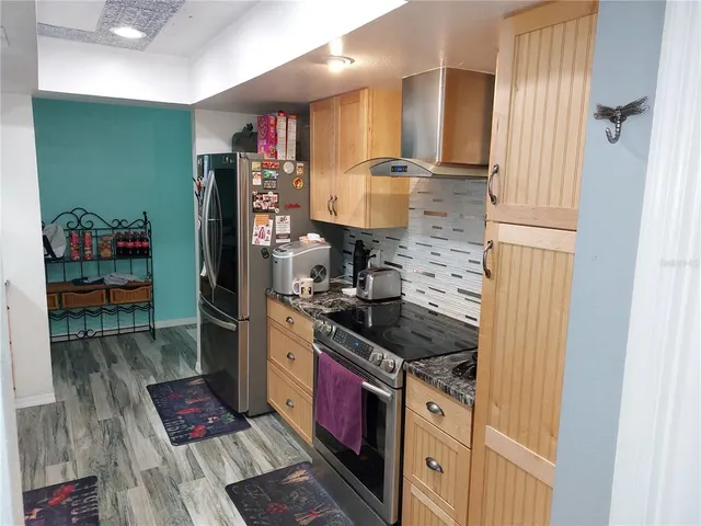 a kitchen with stainless steel appliances granite countertop a refrigerator and a stove