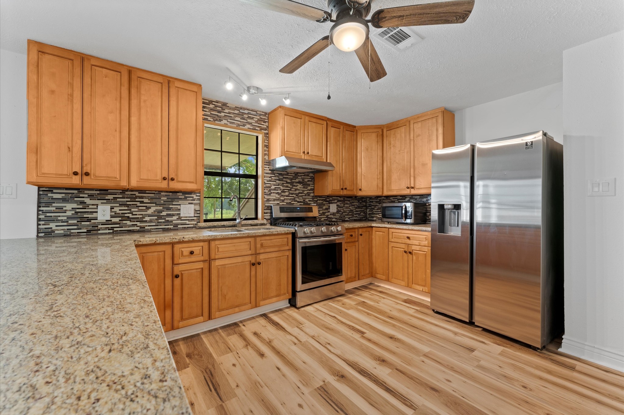 1101 Baker Road Rosenberg, TX 77471 - Photo 32 of 50 a kitchen with stainless steel appliances granite countertop a stove a sink and a refrigerator