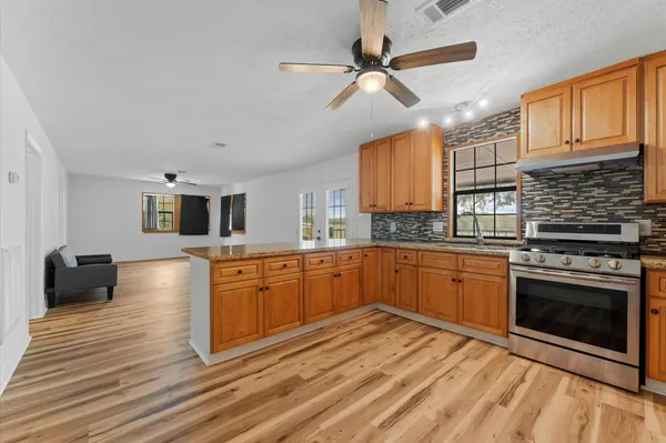 a kitchen with stainless steel appliances granite countertop a stove and cabinets