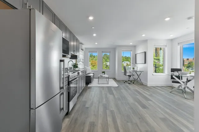 a kitchen with stainless steel appliances a refrigerator and a table