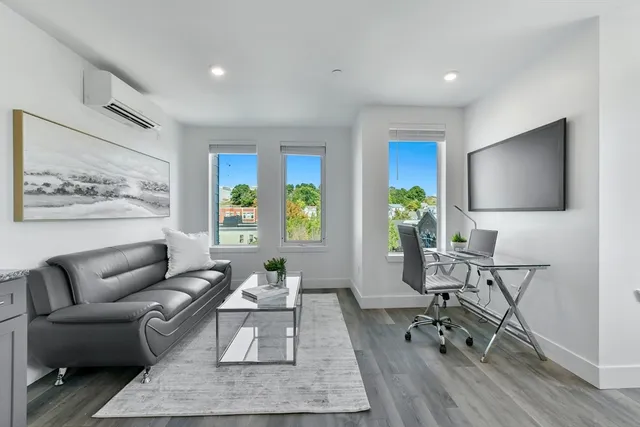 a living room with furniture a rug and a flat screen tv