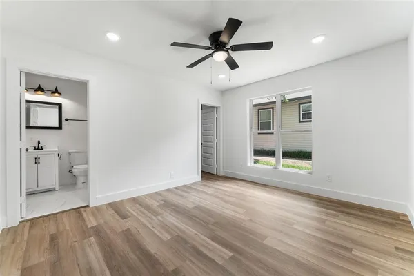 a view of empty room with wooden floor and ceiling fan