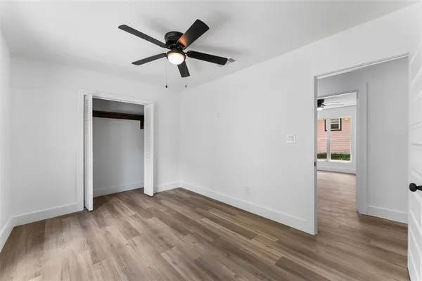 a view of a livingroom with wooden floor and a ceiling fan