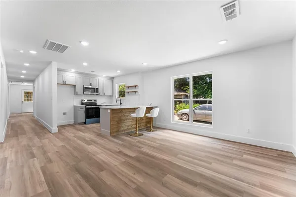 a view of kitchen with stainless steel appliances refrigerator microwave and stove