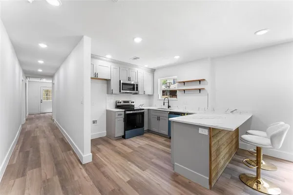 a kitchen with a sink a counter top space stainless steel appliances and cabinets