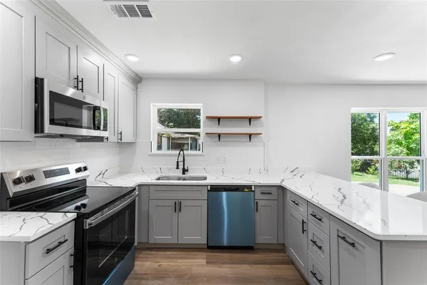a kitchen with a sink stove top oven and microwave