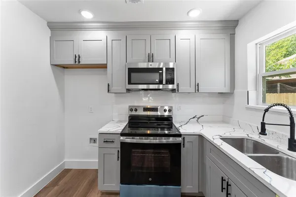 a kitchen with granite countertop a stove and a sink