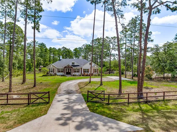 a view of a house with swimming pool and a big yard