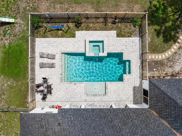 an aerial view of a house with a yard basket ball court and outdoor seating