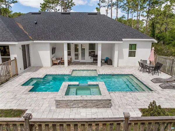 an aerial view of residential house with outdoor space and trees all around