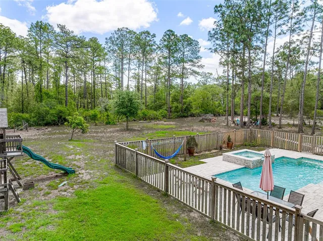 an aerial view of a house with swimming pool and garden