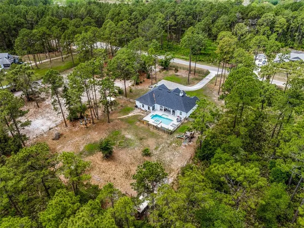 a view of a house with a backyard and a park